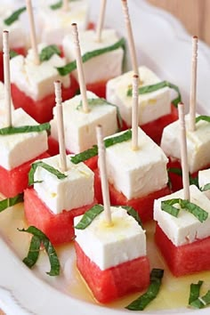 watermelon and mozzarella bites are arranged on a plate with toothpicks