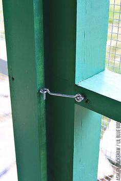 an open green door with a metal handle