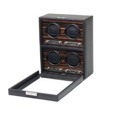 "Roadster" Black, Ebony Macassar Quadruple Watch Winder by Wolf Designs. Wolf Designs' "Roadster" quadruple watch winder has a distinctive look with black pebble faux leather and an ebony macassar wood veneer faceplate. Meticulously engineered, the design includes silvery textured silk lining, a locking glass cover, backlit LCD display, and chrome finished hardware. With a quadruple winding module for four watches, it can be set between 300 and 1200 TPD. You can double the amount of TPD by selec Watch Safes, Polished Wood, Universal Adapter, Wolf Design, Watch Winder, Aging Wood, Wood Polish, Key Lock, Glass Cover