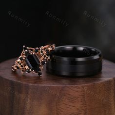 two black rings sitting on top of a wooden table next to an object with gold accents