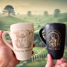 Discover the Charm and Warmth of "The Heart of the Shire" Set by Donovan Pottery Immerse yourself in the serene and delightful world of the Shire with The Heart of the Shire Set, a pair of beautifully designed mugs inspired by the beloved Hobbits. Each mug in this exclusive set features unique, hand-drawn illustrations in 22k gold, capturing the essence of the peaceful and joyful life in the Shire. Designs Included: Home is Behind" Mug: Featuring a charming depiction of a Hobbit door with a book Lotr Pottery, Hobbit Door, Joyful Life, Hobbit Hole, The Shire, Eco Friendly Travel, Gold Ceramic, Customer Testimonials, Mug Set