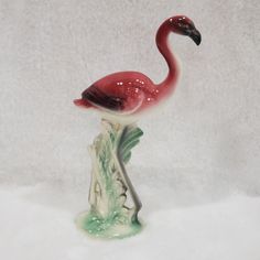 a pink flamingo figurine sitting on top of a white surface