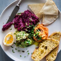 a white plate topped with different types of food next to a knife and some tortilla chips