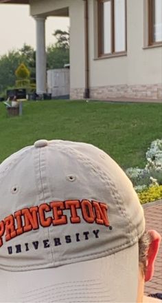 a baseball cap with princeton university embroidered on the front sits in front of a house