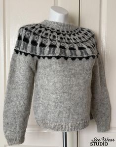 a gray sweater with black and white designs on it