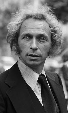 black and white photograph of a man in suit and tie looking at the camera with serious look on his face