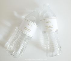 two bottled water bottles sitting next to each other on top of a white countertop