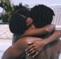 two women hugging each other in front of a swimming pool