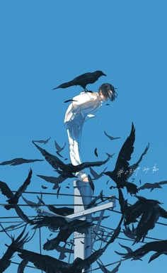 a man standing on top of a pole surrounded by black birds flying around his body