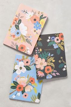 three notebooks with flowers on them are shown in the same page, and one is for