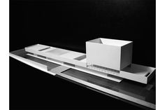 an architectural model is displayed on a black surface with reflective surfaces and white boxes in the foreground