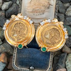 These Robert Bartholomew designed earrings are each centered with an Italian gold toned base metal token. The token depicts on the obverse with a Roman woman in profile wearing a leaf headdress, earrings and a beaded necklace . The reverse of the token depicts a soldier scene. The frame of the earrings are each accented with one (1), bezel set, round cabochon cut natural emerald and twelve (12), bead set, round brilliant cut diamonds. The earrings measure 31mm wide and is finished with omega sty Medallion Earrings, A Soldier, Bead Set, Matching Necklaces, Natural Emerald, Round Brilliant Cut Diamond, Modern Jewelry, Round Brilliant Cut, Base Metal