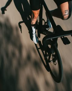 a man riding a bike down a street with tattoos on his arm and leggings