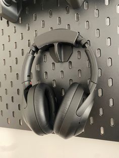 headphones are sitting on a shelf in front of a metal wall with rivets