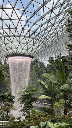 an indoor waterfall in the middle of a tropical garden