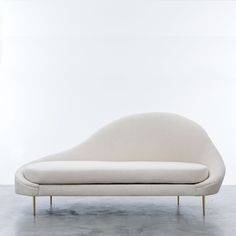 a white couch sitting on top of a cement floor