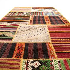 a multicolored patchwork rug with many different colors and patterns on it's sides