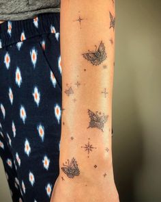 a woman's arm with tattoos on it and stars all over the entire arm