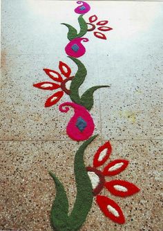 a long line of flowers painted on the ground with red and green leaves in it