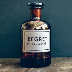 a black and white photo of a bottle with the word reget corrosive on it