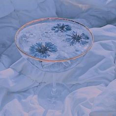 a glass filled with water sitting on top of a bed