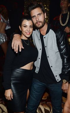 a man and woman standing next to each other in front of a crowd at a party