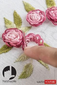 someone is working on some flowers with yarn