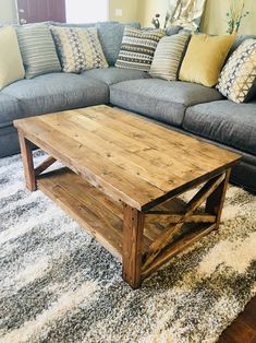 a living room with a gray couch and wooden coffee table in front of a window