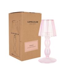 a pink lamp sitting next to a cardboard box