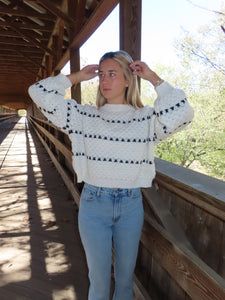 a woman standing on a bridge with her hands behind her head and looking off into the distance