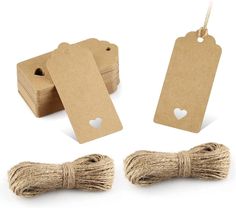 twine and tags on white background with heart cutout in middle, two small hearts at the end