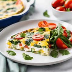 a white plate topped with a slice of pizza and veggies next to a bowl of tomatoes