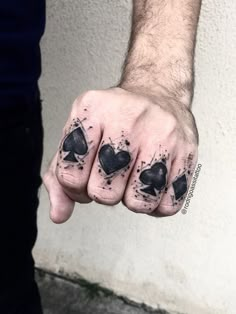 a man's hand with four playing cards tattooed on it