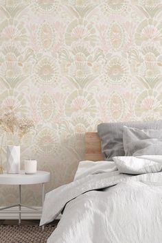 a white bed sitting next to a wall with a flower pattern on it