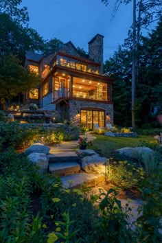 a house that is lit up at night with steps leading to the front door and windows