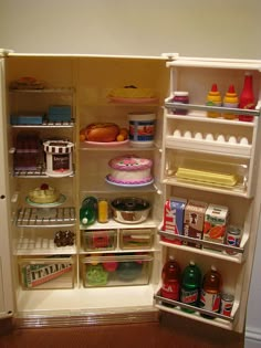 an open refrigerator filled with food and condiments on the inside, including cake