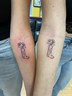 two people with tattoos on their arms and one has a cowboy boot in the middle