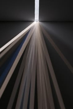 the light is shining brightly through an opening in a room with black and white stripes