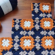 two crocheted squares are sitting on a table