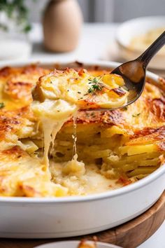 a close up of a casserole being lifted with a spoon