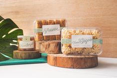 three small packages of soap sitting on top of a wooden stand next to a plant