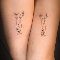 two tattoos on the legs of women with flowers in their butts, one is holding onto another woman's leg