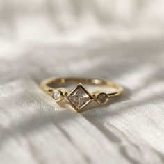 a diamond ring sitting on top of a white sheet