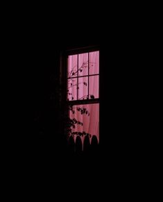 an open window at night with pink light coming through the window and leaves on the windowsill