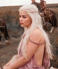 a woman with long white hair sitting on the ground