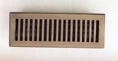 a metal vent cover mounted to the side of a wall with black and white stripes on it