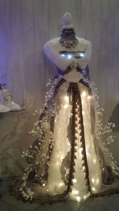 a mannequin is adorned with white flowers and lights