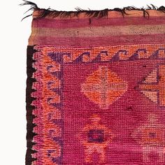 an old rug with fringes on the bottom and pink, orange and purple colors