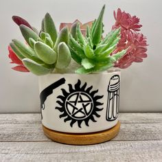 a potted plant sitting on top of a wooden table filled with flowers and plants