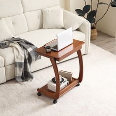 a white couch sitting next to a table with a laptop on it